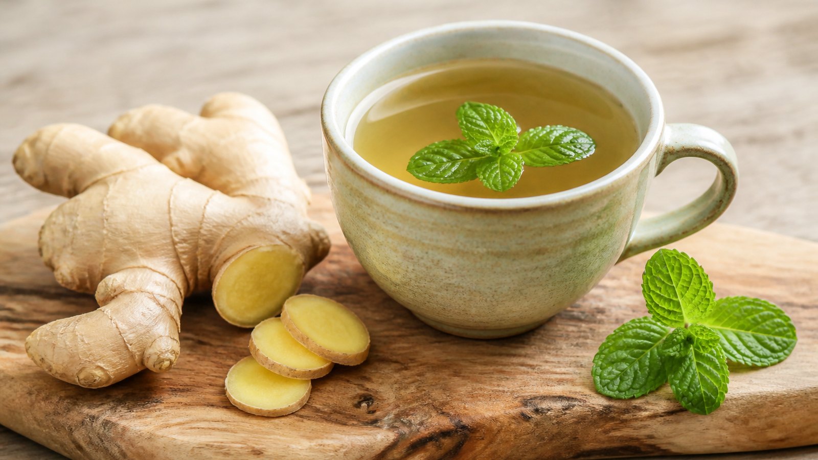 Fresh ginger and a cup of herbal tea on a wooden board